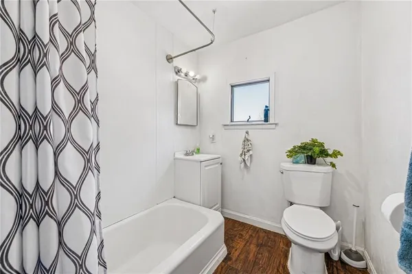 a white toilet sitting next to a white tub