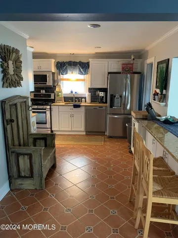 a kitchen with stainless steel appliances a stove a sink and a microwave