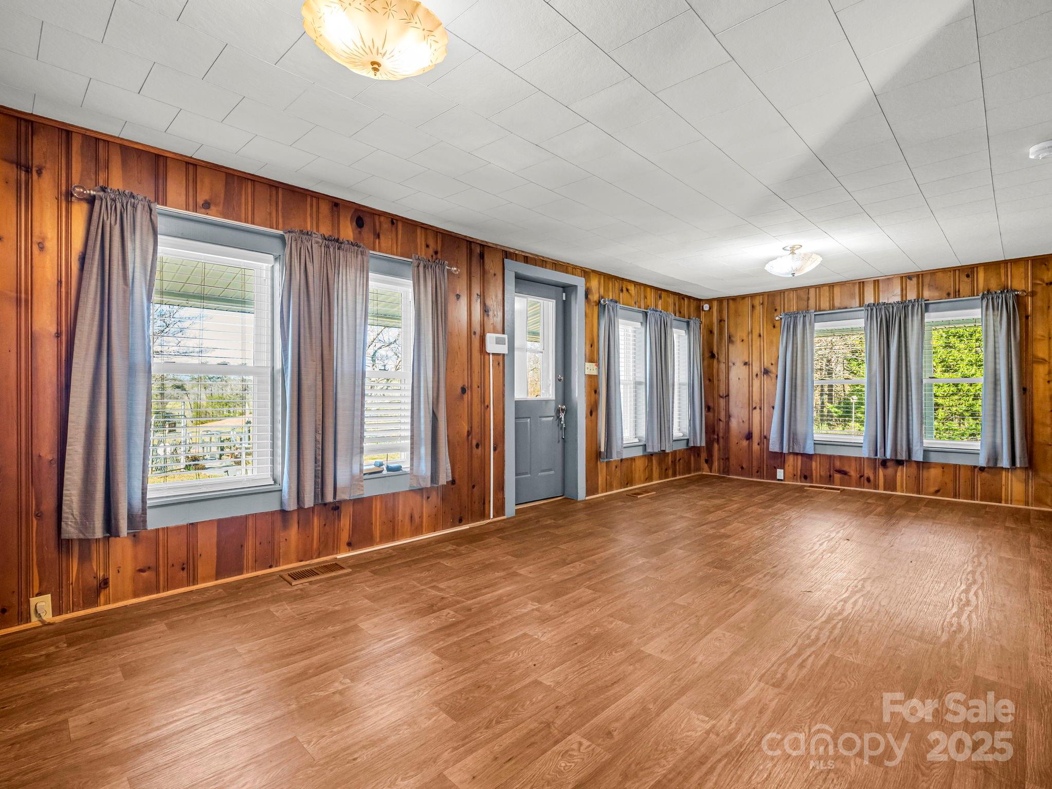 620 Smith Waldrop Road Columbus, NC 28722 - Photo 3 of 42 an empty room with wooden floor and windows