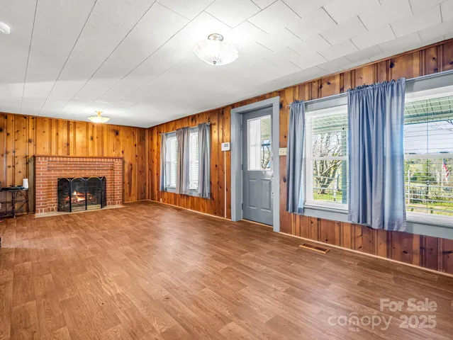 a view of an empty room with a fireplace and a window