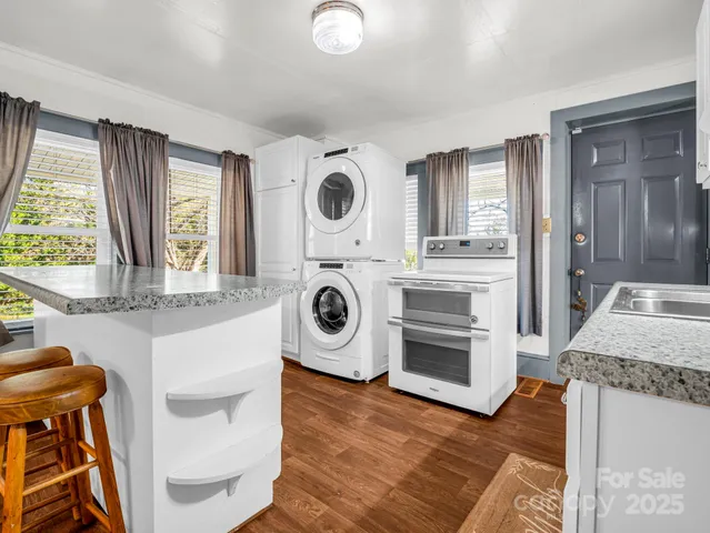 a view of kitchen with sink and refrigerator
