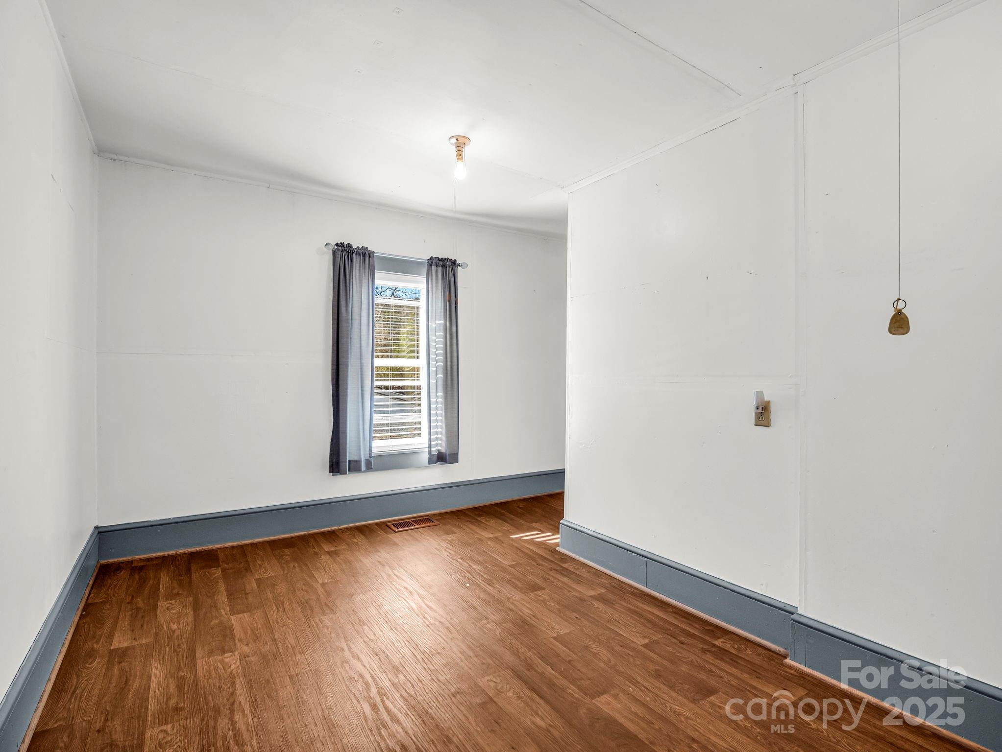 620 Smith Waldrop Road Columbus, NC 28722 - Photo 10 of 42 a view of an empty room with wooden floor and a window