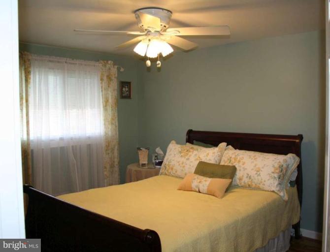 7811 Harold Road Dundalk, MD 21222 - Photo 5 of 10 a bedroom with a bed and a chandelier