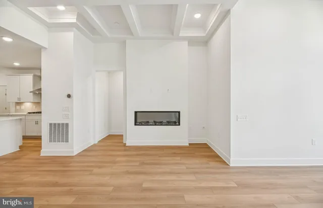 a view of a hallway with wooden floor and entryway