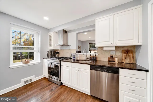 a kitchen with granite countertop white cabinets and white appliances