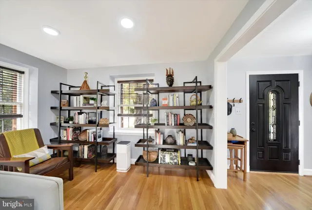 a living room with furniture a rug and a book shelf