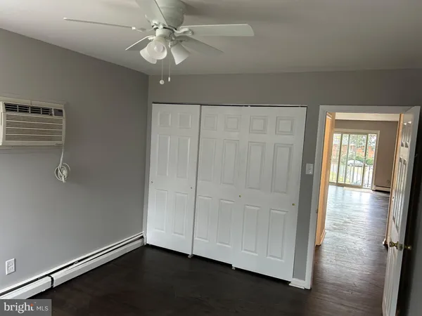 an empty room with wooden floor cabinet and windows