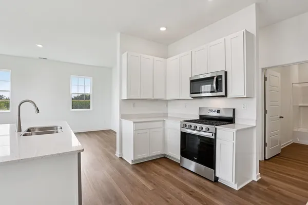 a kitchen with stainless steel appliances a stove microwave and sink