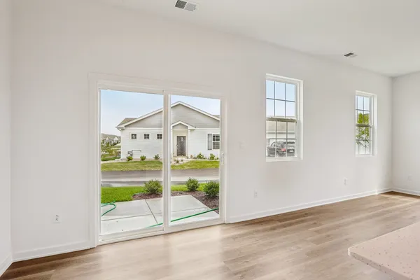 a view of a bedroom with wooden floor and windows