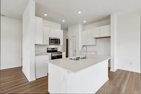 a kitchen with sink a microwave and refrigerator