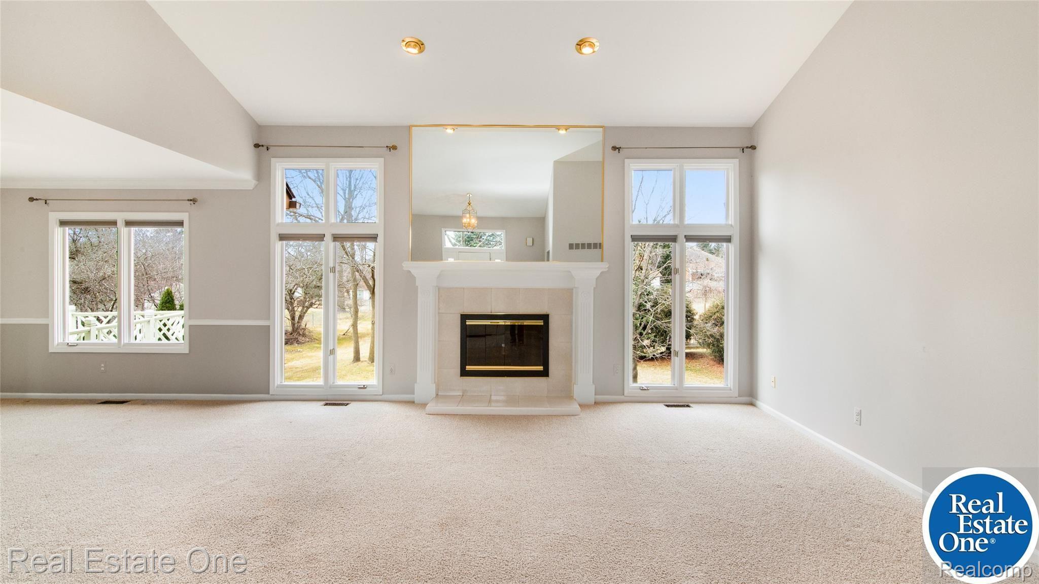 19449 Newburgh Road Livonia, MI 48152 - Photo 10 of 41 Gas fireplace surrounded with large windows that overlook the backyard.