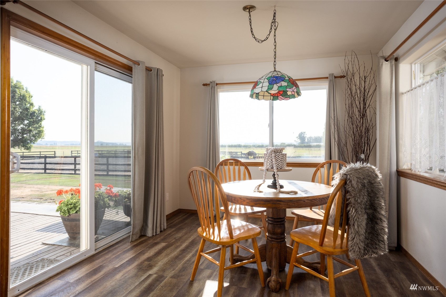 15606 Beaver Marsh Road Mount Vernon, WA 98273 - Photo 11 of 39 a dining room with wooden floor a chandelier a glass table and chairs