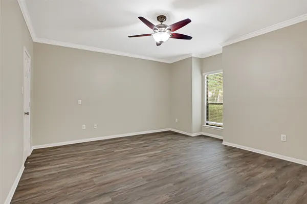 a view of an empty room with window and a ceiling fan