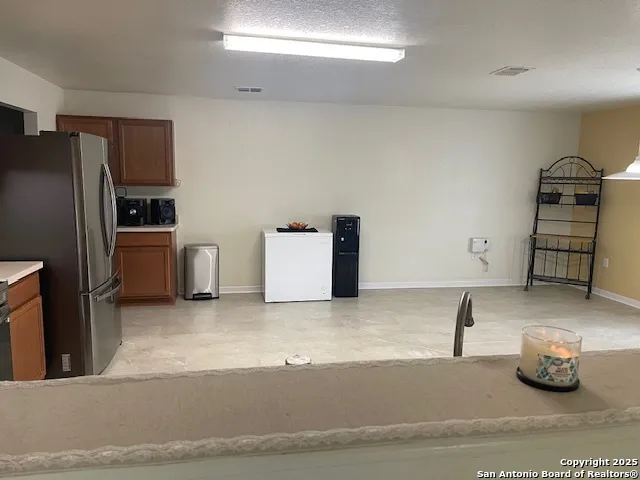 a kitchen with granite countertop a refrigerator and stove
