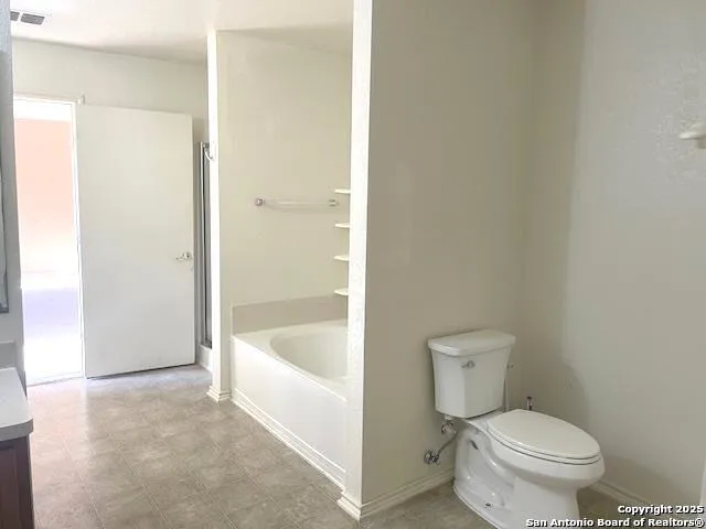 a white toilet sitting next to a bath tub