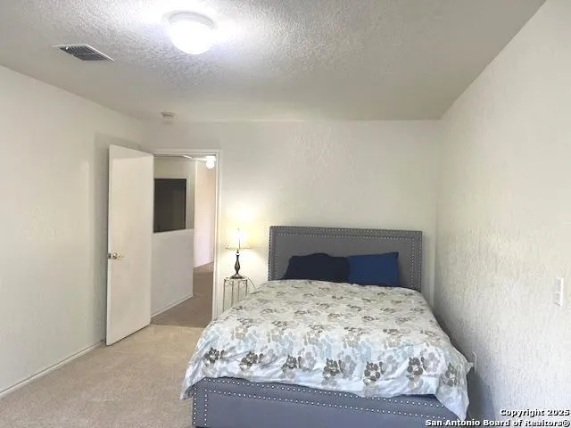 a bedroom with a bed and painting on the wall