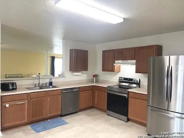 a kitchen with a sink stove and refrigerator
