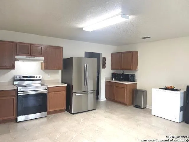 a kitchen with a refrigerator sink and stove