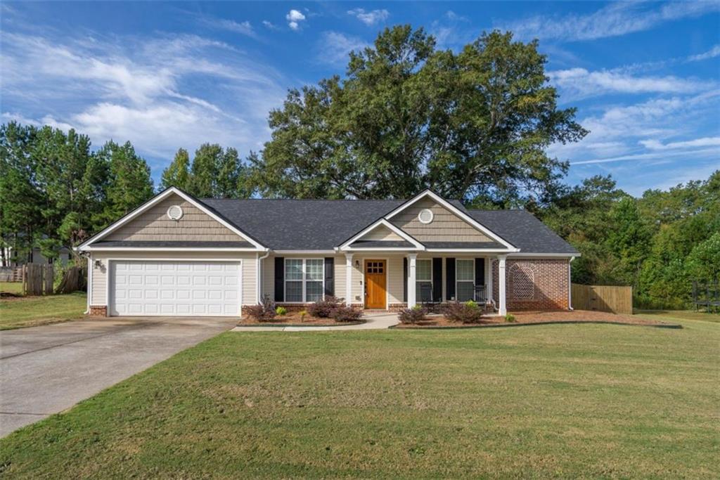 a front view of a house with a yard and trees
