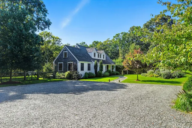 a front view of a house with a yard and trees