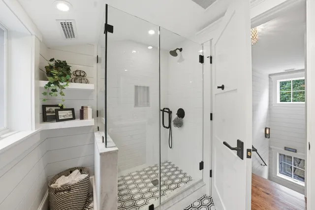 a bathroom with a sink a mirror a window and a bathtub