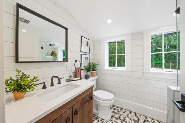 a bathroom with a sink a toilet and mirror