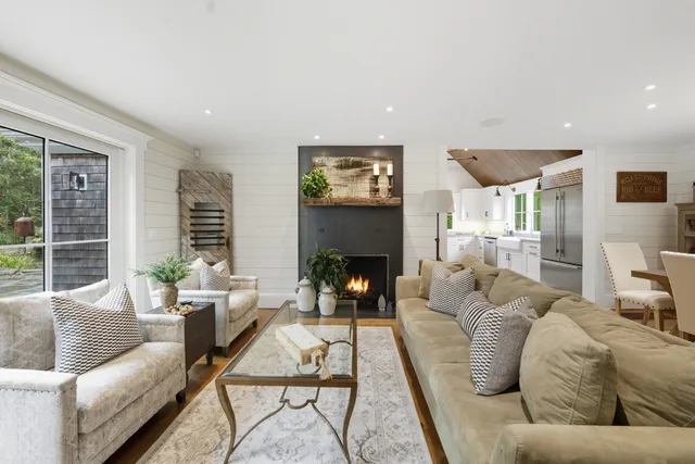 a living room with furniture fireplace and a large window