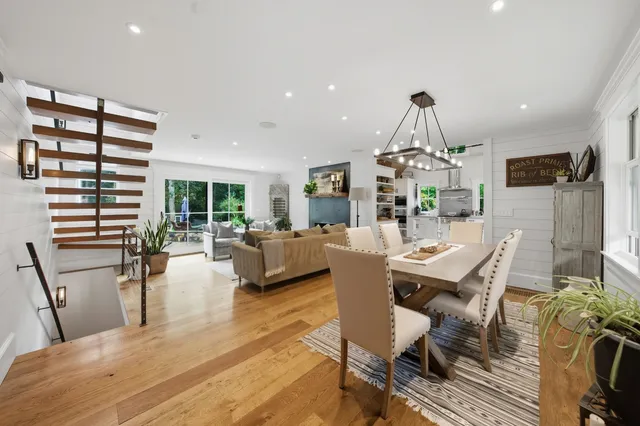 a living room with furniture a dining table and a chandelier