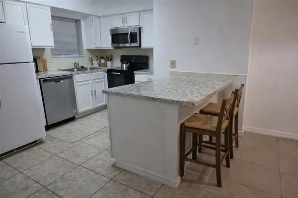 a kitchen with granite countertop a sink appliances and cabinets