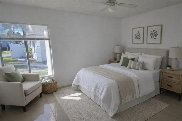 a bedroom with a bed a couch and a window