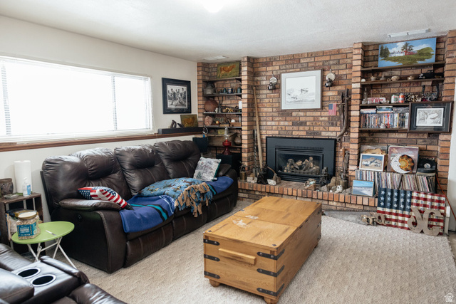 322 Bailey Creek Road Soda Springs, ID 83276 - Photo 16 of 32 Living area featuring a brick fireplace with a black insert, flanked by built-in shelving