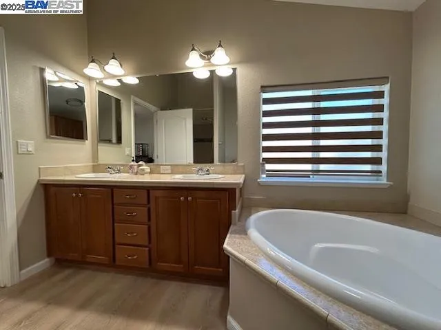 a bathroom with a tub sink and a mirror