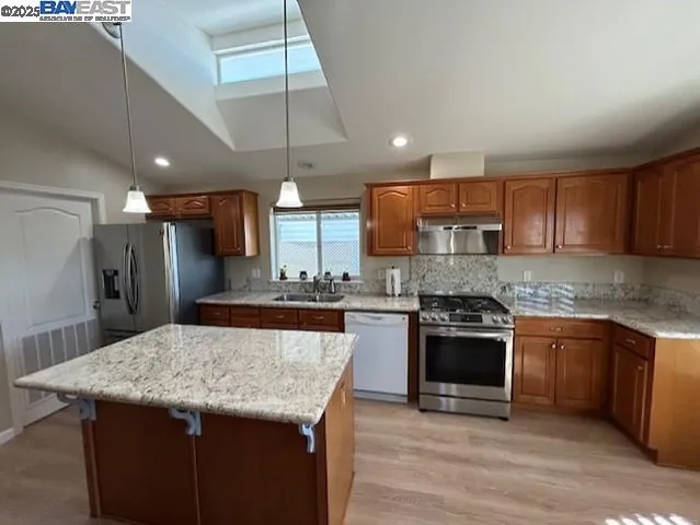 a kitchen with stainless steel appliances granite countertop a sink stove and refrigerator