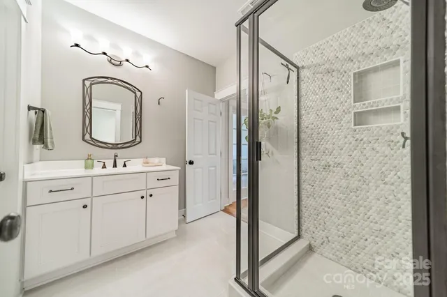 a bathroom with a double vanity sink mirror and shower