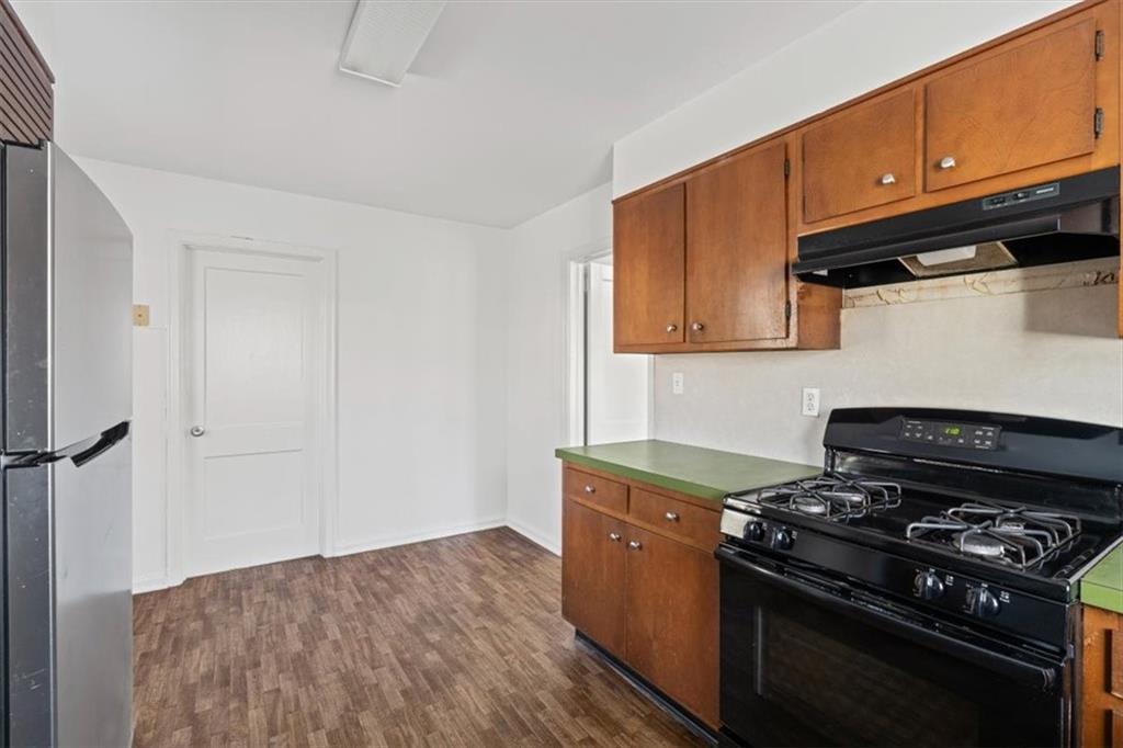 449 10th Street Northwest Atlanta, GA 30318 - Photo 12 of 40 a kitchen with stainless steel appliances wooden cabinets and a stove top oven