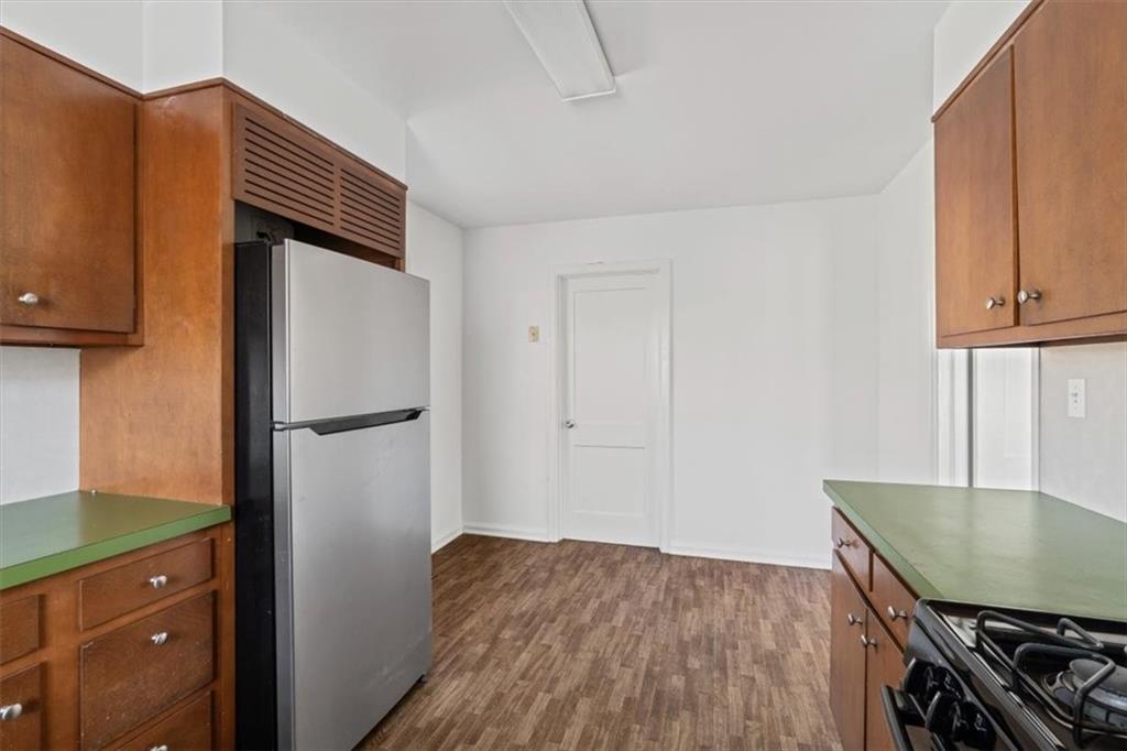 449 10th Street Northwest Atlanta, GA 30318 - Photo 13 of 40 a kitchen with stainless steel appliances granite countertop a refrigerator a stove and a sink with wooden cabinets