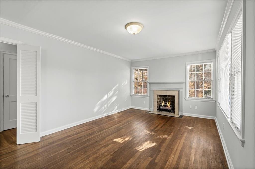 449 10th Street Northwest Atlanta, GA 30318 - Photo 4 of 40 an empty room with wooden floor fireplace and windows
