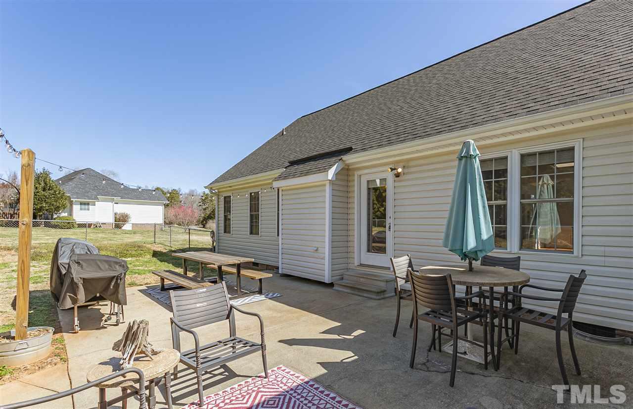 156 Fork Junction Road Timberlake, NC 27583 - Photo 11 of 30 a view of a patio with table and chairs and floor to ceiling window