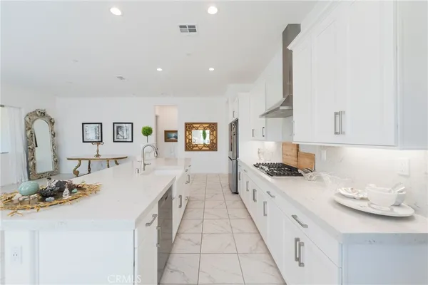 a large kitchen with stainless steel appliances kitchen island granite countertop a sink and cabinets