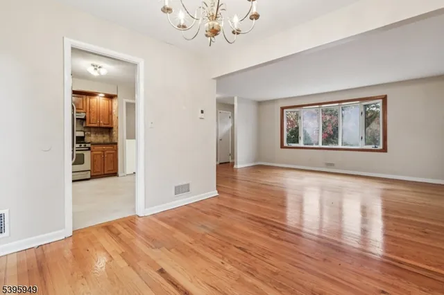 a kitchen with stainless steel appliances granite countertop a refrigerator a sink and white cabinets