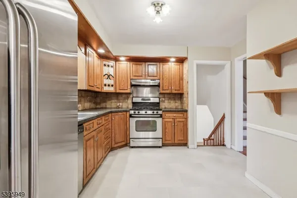 a kitchen with granite countertop a sink stainless steel appliances and cabinets