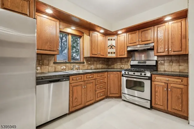 a view of a hallway with wooden floor and a bathroom