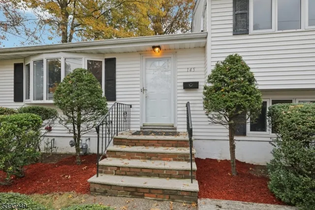 a view of front door with hallway and wooden floor