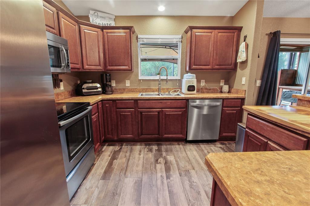 6312 Central Avenue Coleman, FL 34785 - Photo 19 of 25 a kitchen with stainless steel appliances granite countertop a stove a sink dishwasher and a microwave oven with cabinets
