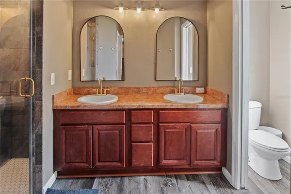 a bathroom with a granite countertop toilet sink and mirror