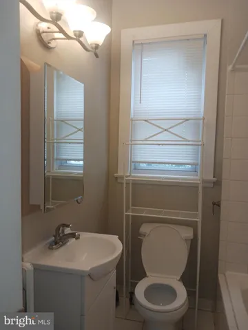 a bathroom with a toilet sink vanity and mirror
