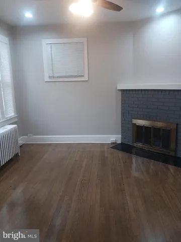 an empty room with wooden floor and fireplace