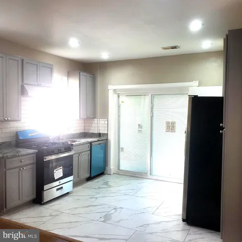 a large kitchen with stainless steel appliances granite countertop a refrigerator and a sink