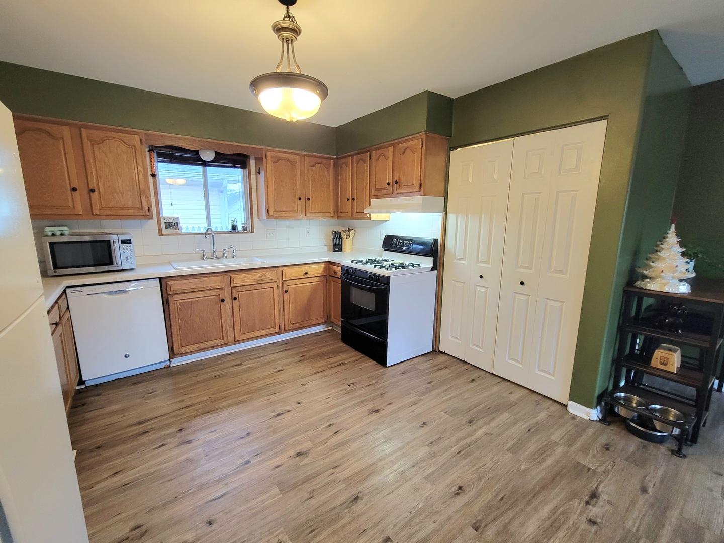486 West Washington Street St. Anne, IL 60964 - Photo 7 of 14 a kitchen with wooden floors and white cabinets
