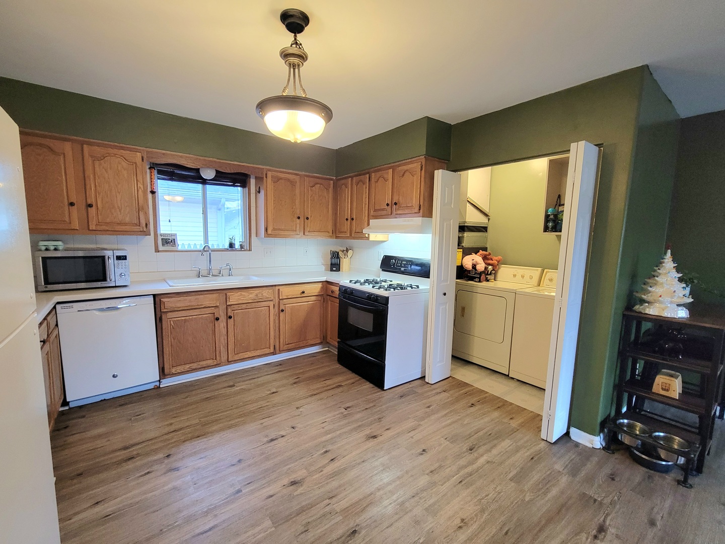 486 West Washington Street St. Anne, IL 60964 - Photo 8 of 14 a kitchen with wooden floors and white cabinets